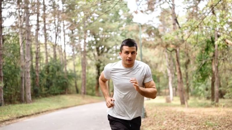 A man wearing a T-shirt is running.