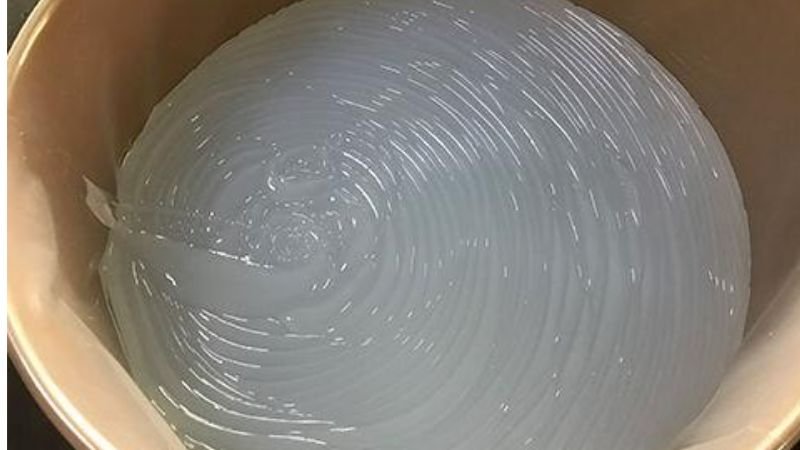 Translucent liquid silicone raw material in a mixing container, used in the manufacturing of silicone bras and nipple covers.